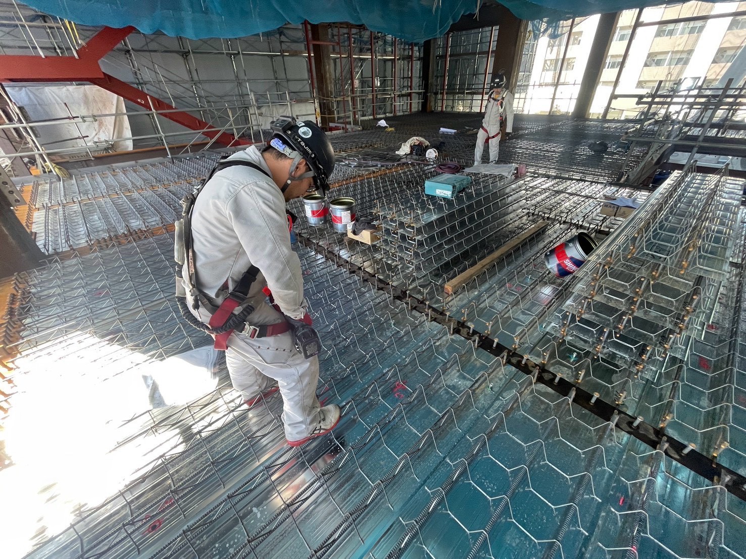 仲間とともに建物の電気設備を施工する現場